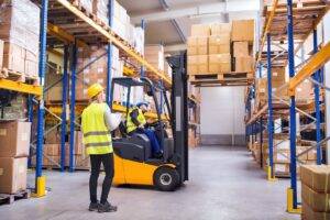 Warehouse workers operating forklift